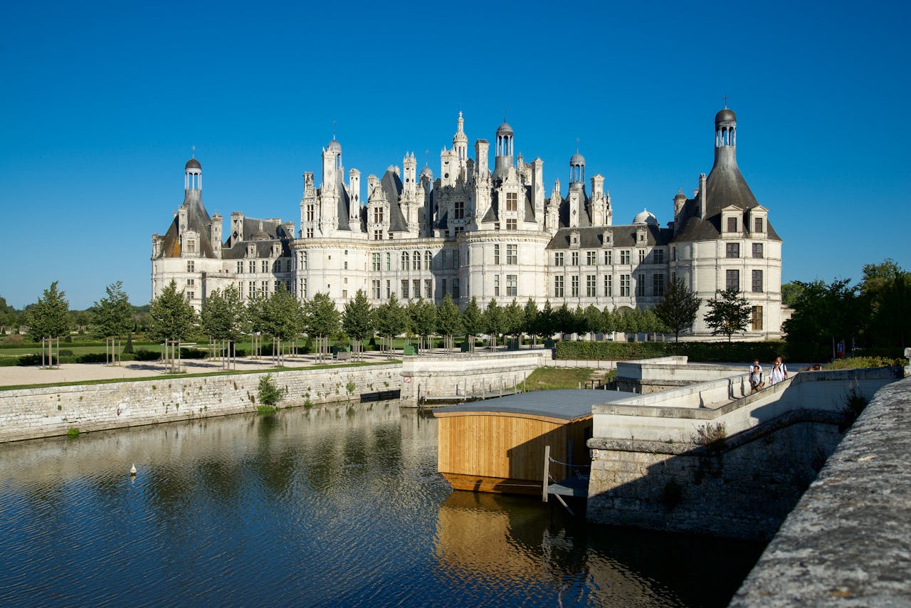 Majestic Château de Chambord surrounded by serene summer landscapes, a masterpiece of French Renaissance architecture.
