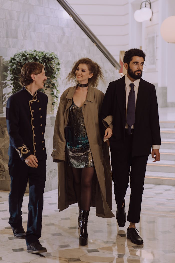 A couple walks with a concierge in a luxurious hotel lobby, showcasing hospitality.